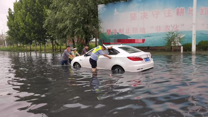 暴雨突袭中牟 交警积水中赤脚救援抛锚车辆