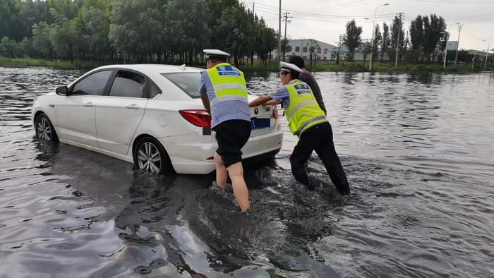 暴雨突袭中牟 交警积水中赤脚救援抛锚车辆