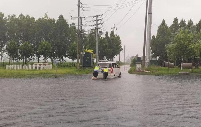 暴雨突袭中牟 交警积水中赤脚救援抛锚车辆