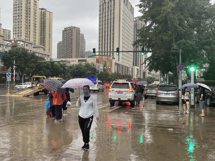 北京门头沟城区主干路有部分积水和淤泥，环卫工人正抓紧清理