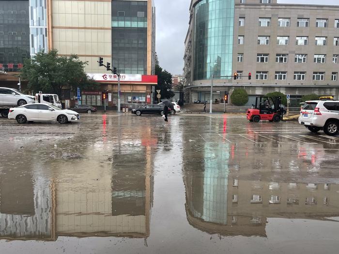 北京门头沟城区主干路有部分积水和淤泥，环卫工人正抓紧清理