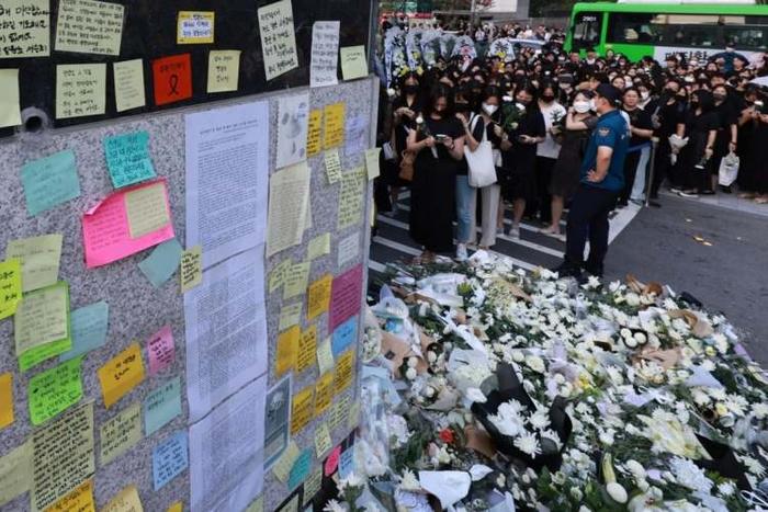 7月20日,首尔南部的一小学前门,哀悼者排队向自杀身亡的老师表示哀悼(韩媒)