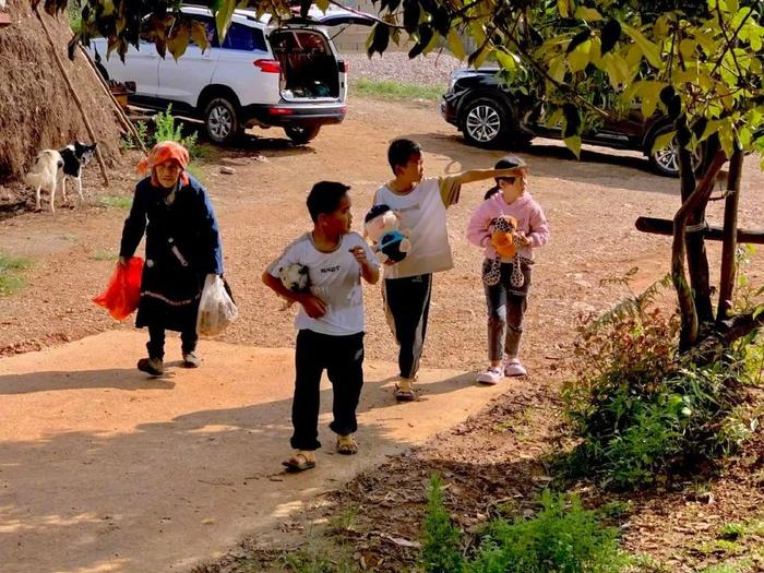 捡完菌子来售卖的彝族村民和她的孙辈们。