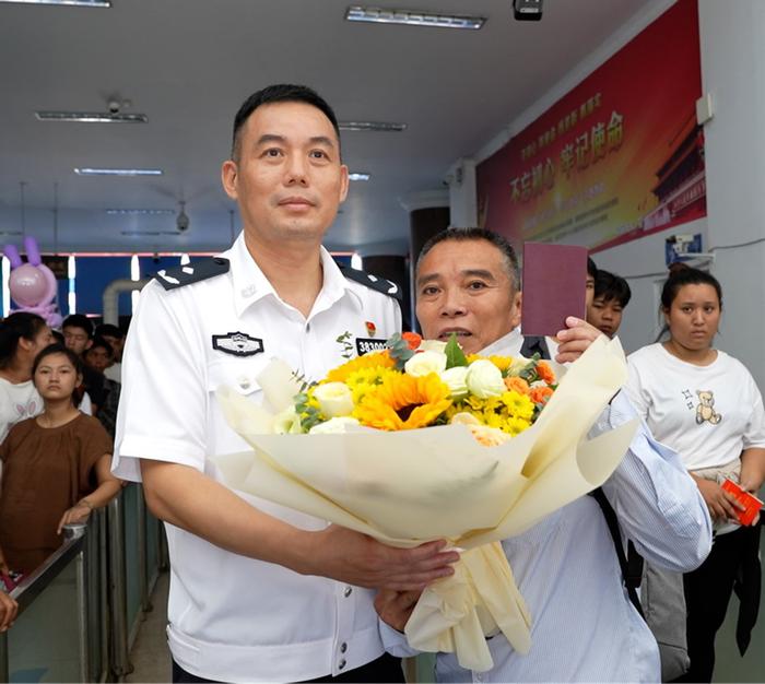 瑞丽出入境边防检查站为第一名吃因私普通护照旅客送上鲜花(青林波 摄)
