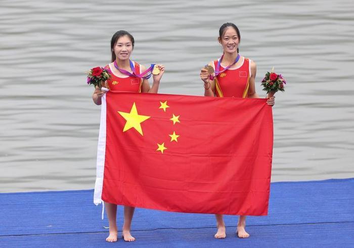 9月24日,杭州亚运会首金的获得者、中国赛艇运动员邹佳琪(左)/邱秀萍在颁奖仪式上庆祝。新华社记者 杜潇逸 摄
