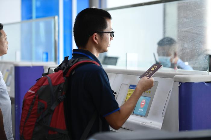 旅客持因私护照出境旅客办理出境手续(青林波 摄)