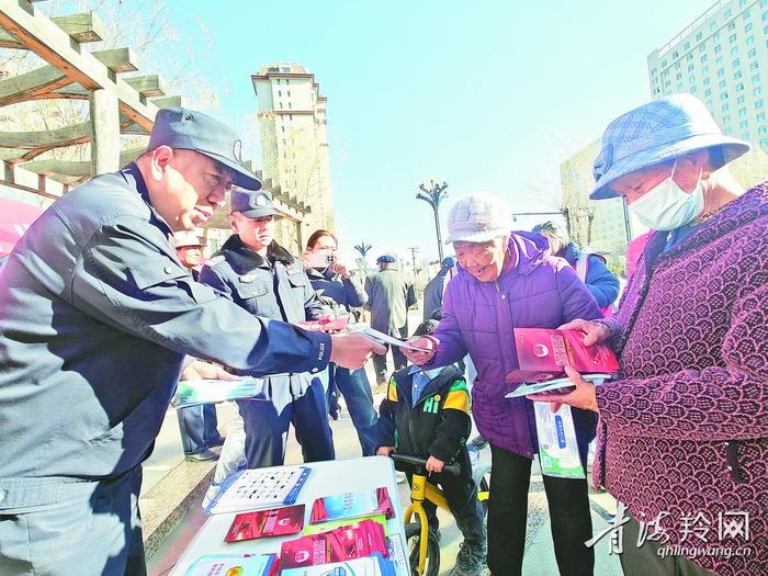 派出所民警向居民发放宣传手册。本报实习记者 杨红霞 摄