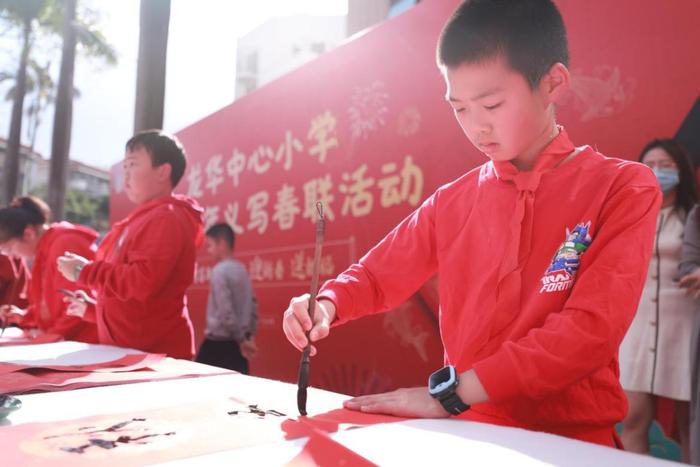 龙华中心小学举行义写春联活动，师生挥笔泼墨传递祝福与温暖