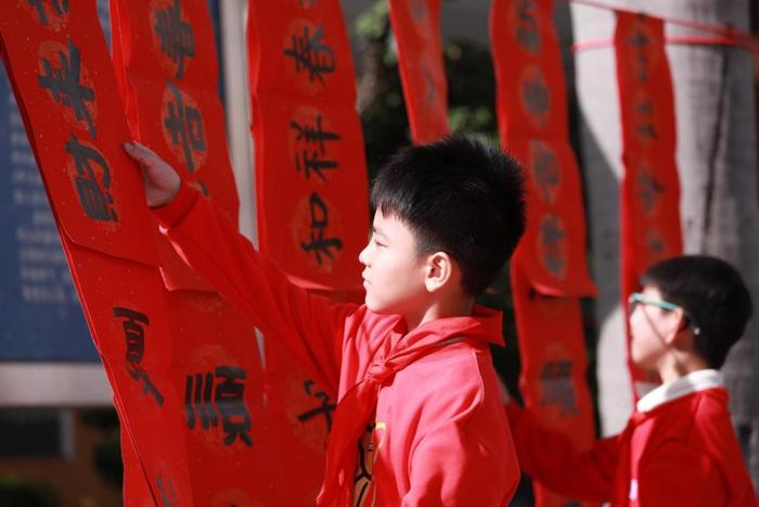 龙华中心小学举行义写春联活动，师生挥笔泼墨传递祝福与温暖