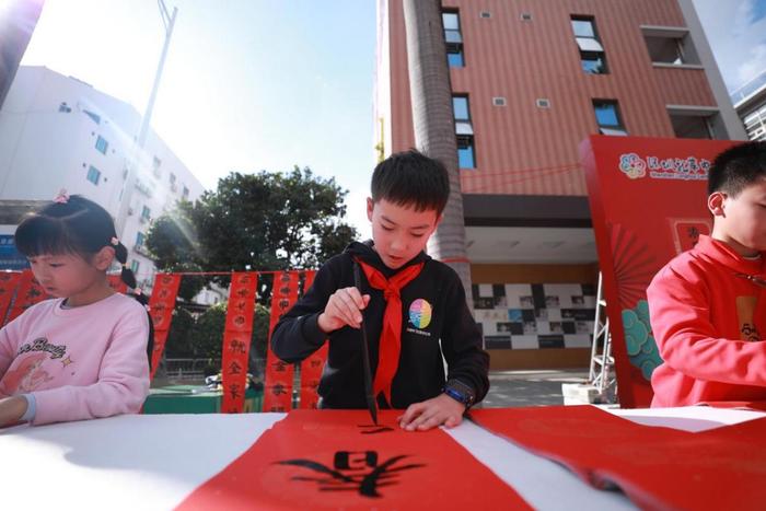 龙华中心小学举行义写春联活动，师生挥笔泼墨传递祝福与温暖