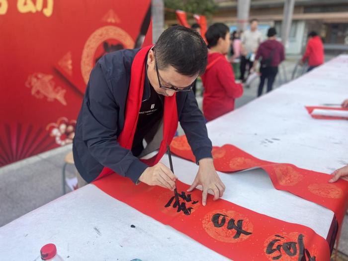 龙华中心小学举行义写春联活动，师生挥笔泼墨传递祝福与温暖