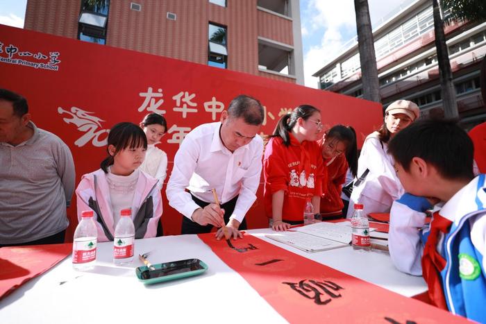 龙华中心小学举行义写春联活动，师生挥笔泼墨传递祝福与温暖