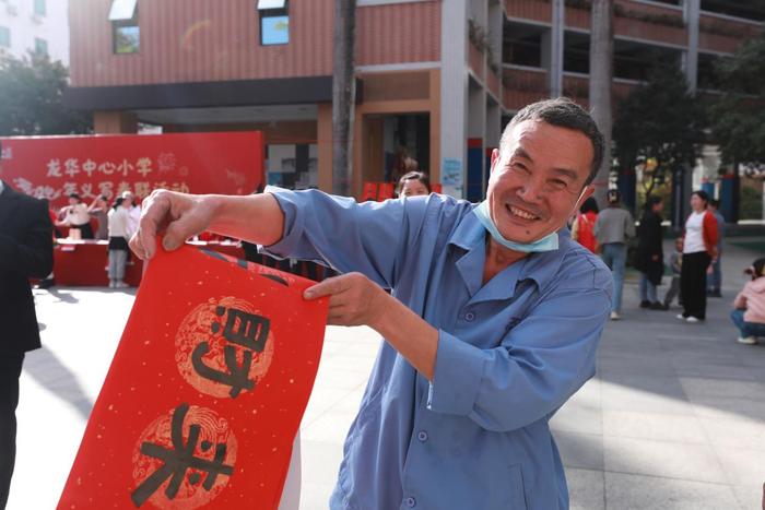 龙华中心小学举行义写春联活动，师生挥笔泼墨传递祝福与温暖