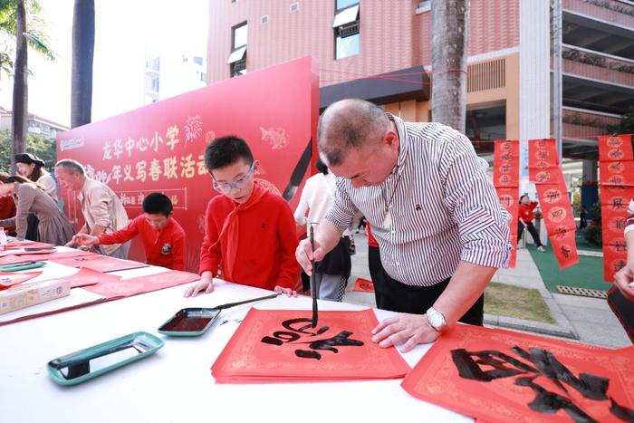 龙华中心小学举行义写春联活动，师生挥笔泼墨传递祝福与温暖