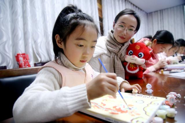 家长指导孩子绘制龙年年画 通讯员 曹忠宏 吴芳芳 摄
