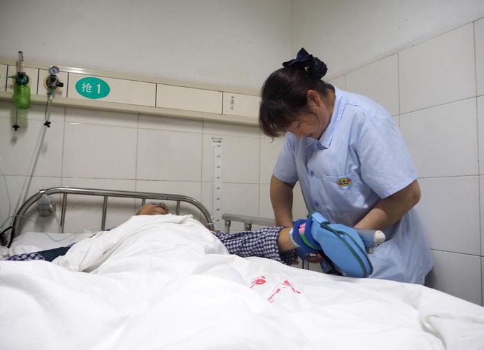 ▲护工在重症室为病人擦洗、护理 图据IC photo