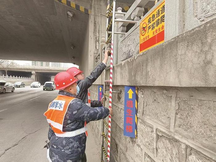 工作人员擦拭沿京广铁路地道桥下救生爬梯
