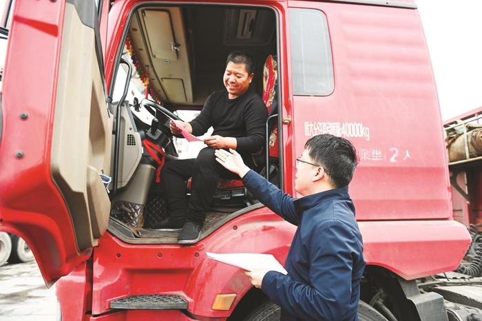 肥乡区人社局工作人员给当地运输司机送上相关政策明白卡
