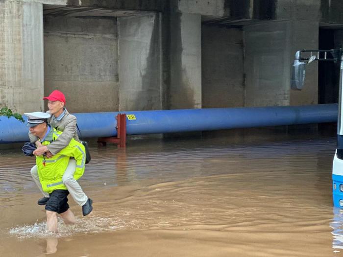 “上来，我背你们过去！”公交车积水中抛锚，长沙县交警罗正益充当“摆渡人”