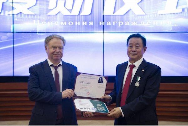 图为:叶戈罗夫—弗拉基米尔先生向李盛学院士颁发勋章及证书