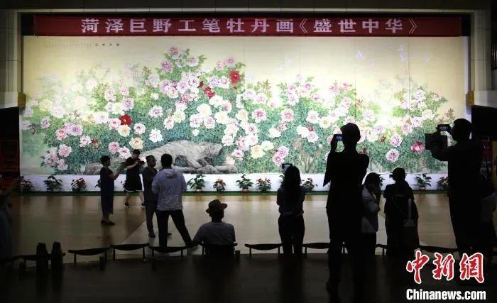 游客在菏泽巨野县书画院欣赏巨幅工笔牡丹画《盛世中华》。沙见龙 摄