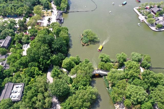 夏秋之交济南大明湖，湖水碧蓝树木葱绿仿佛画卷