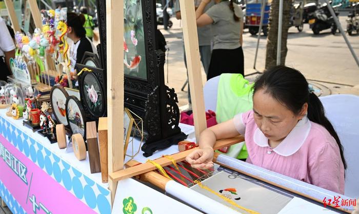 ▲“美丽工坊·幸福集市”,残疾人现场刺绣