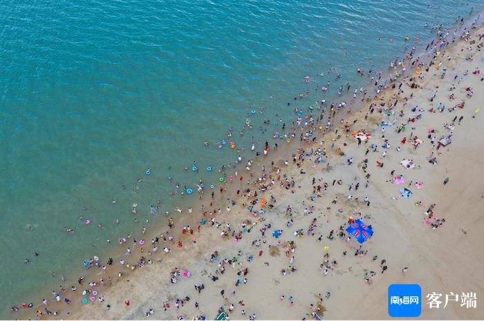 原创组图丨海口市民游客海边“洗龙水”过端午