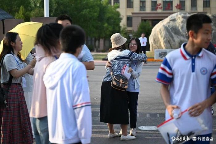 中考首日结束，考生走出考场向陪考老师“汇报”