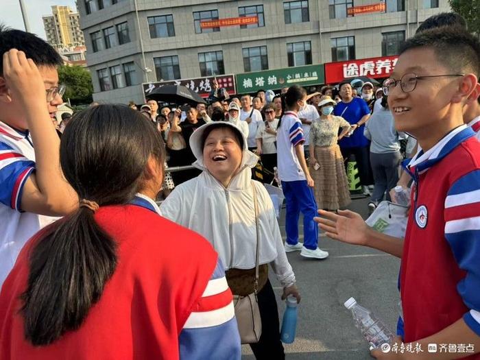 中考首日结束，考生走出考场向陪考老师“汇报”