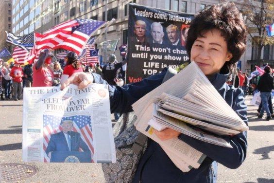 图为“法轮功”教徒分发有关特朗普的《大纪元时报》