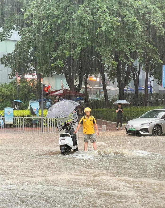 深圳外卖小哥暴雨中守着排水井提醒路人 明云龙：要是行人不小心掉进排水井，后果不堪设想