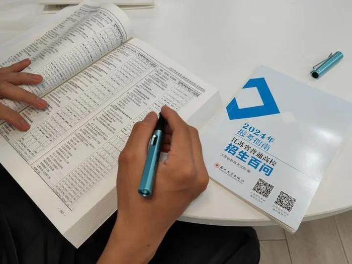6月17日，南京市一名高三考生阅读江苏省教育考试院编制的2024年报考指南。（新华每日电讯记者陈席元摄）
