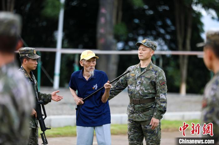 图为抗战老兵孙洪秀(左三)用拐杖为武警广西总队百色支队官兵演示曾经战斗时的刺杀动作。唐明洋摄