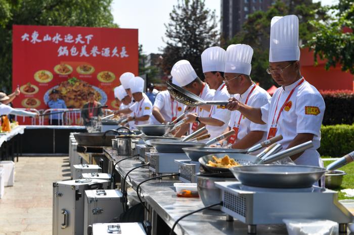 6月29日,专业厨师在锅包肉大赛比赛现场展示锅包肉制作过程。张楠摄(新华社)