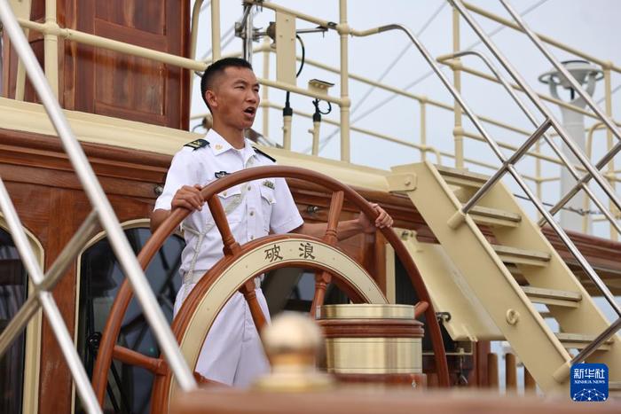 7月22日,中国海军“破浪”号风帆训练舰舵手为武官团成员进行操舵演示。新华社发(李昊天 摄)