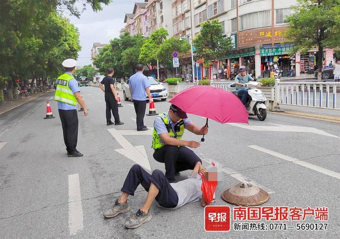 暖心！老人忽然倒在马路上，辅警为其撑伞等待救护车