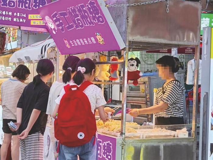 夜市上很多商家售卖蜡瓶糖。 新华社发