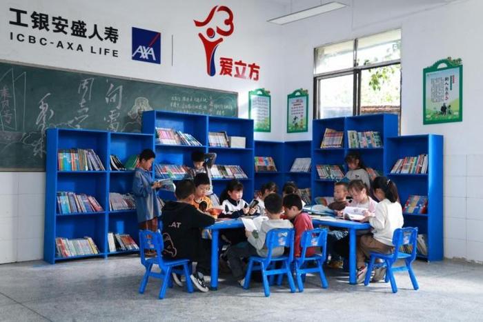 图:山区孩子们在“爱立方”图书室的蓝色书架前沉浸式阅读(工银安盛人寿供图)