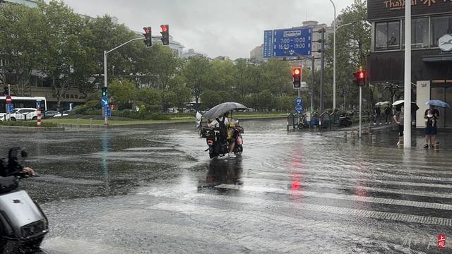 浦东遭遇暴雨，市政工人全力排水，外卖小哥“摆渡”市民过街