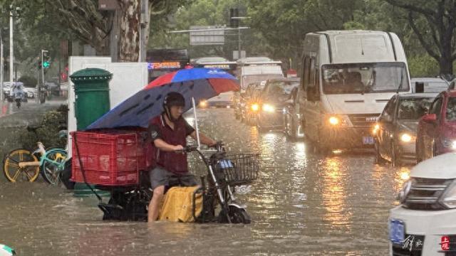 浦东遭遇暴雨，市政工人全力排水，外卖小哥“摆渡”市民过街