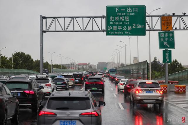 受台风尾部环流影响上海晨间暴雨，延安路高架拥堵，松江大学城学生雨中赶课