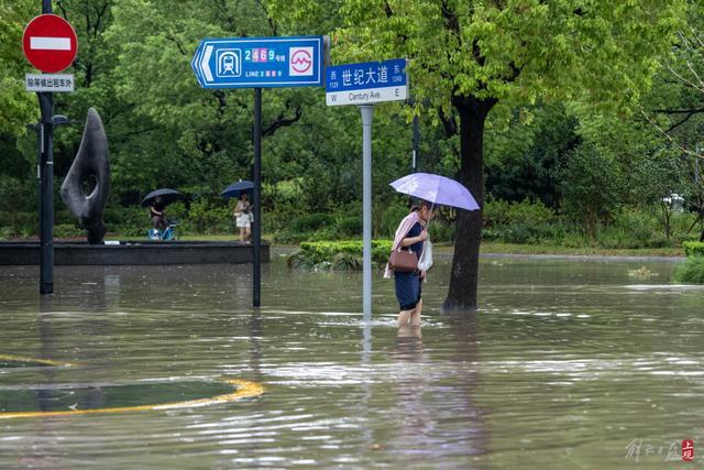 浦东遭遇暴雨，市政工人全力排水，外卖小哥“摆渡”市民过街