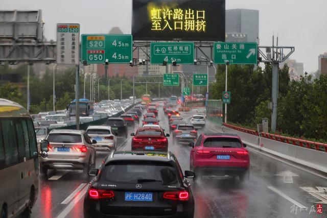 受台风尾部环流影响上海晨间暴雨，延安路高架拥堵，松江大学城学生雨中赶课