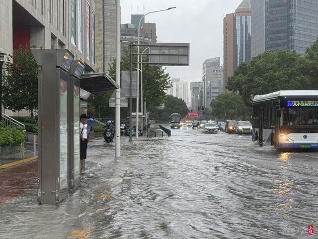 浦东遭遇暴雨，市政工人全力排水，外卖小哥“摆渡”市民过街