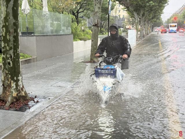 浦东遭遇暴雨，市政工人全力排水，外卖小哥“摆渡”市民过街