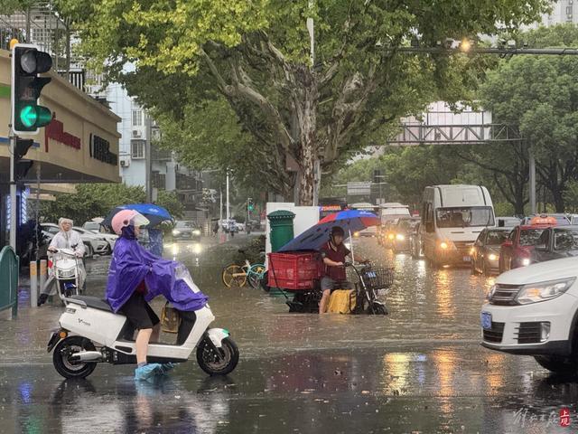 浦东遭遇暴雨，市政工人全力排水，外卖小哥“摆渡”市民过街