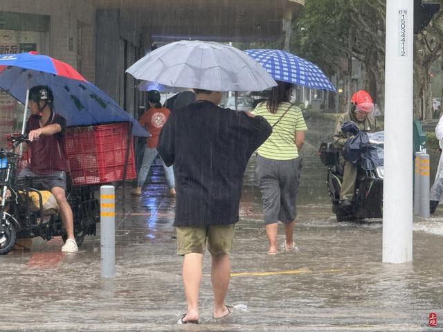 浦东遭遇暴雨，市政工人全力排水，外卖小哥“摆渡”市民过街