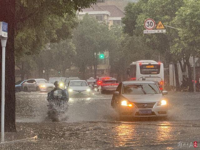 浦东遭遇暴雨，市政工人全力排水，外卖小哥“摆渡”市民过街