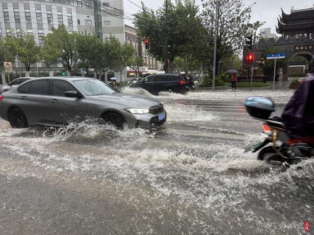 浦东遭遇暴雨，市政工人全力排水，外卖小哥“摆渡”市民过街